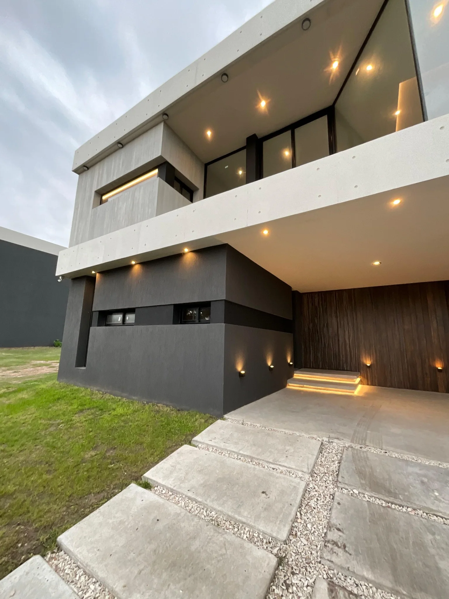 Casa contemporánea de hormigón y revestimiento oscuro