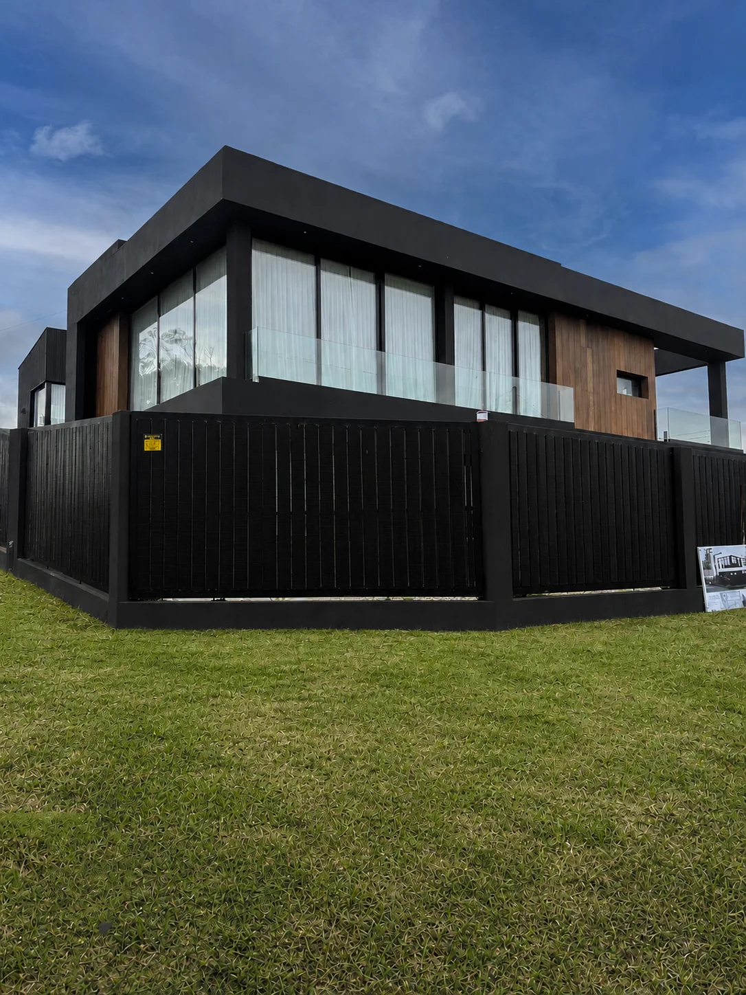 Casa contemporánea de fachada negra, madera y vidrio