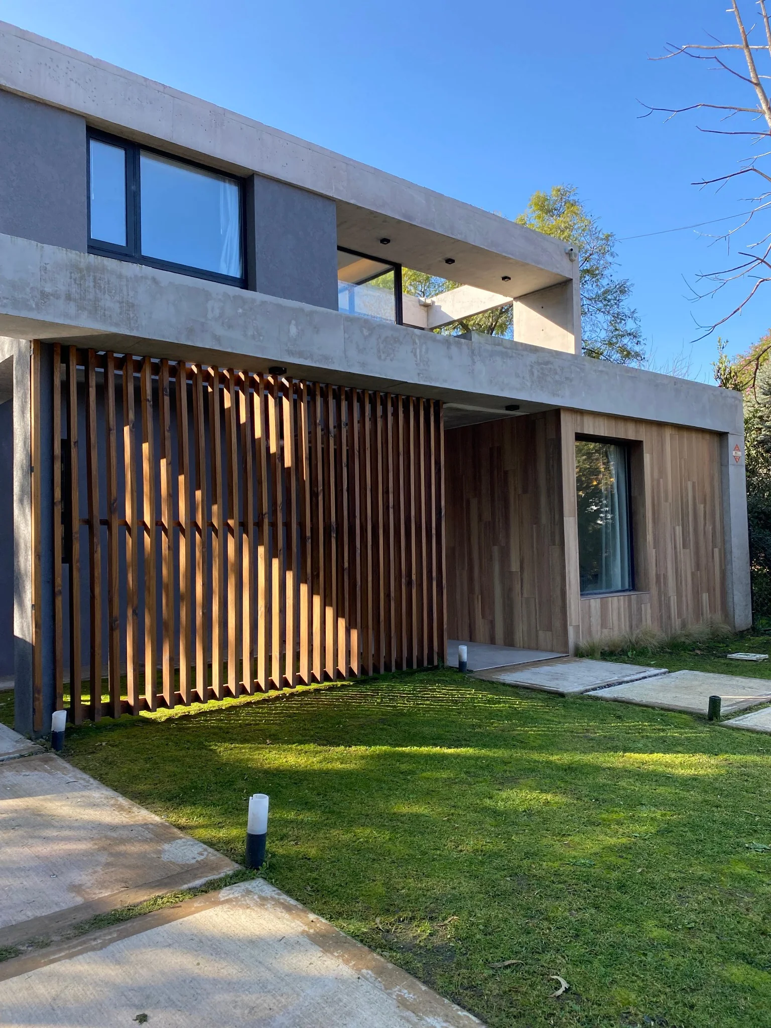 Casa contemporánea de hormigón y parasoles de madera